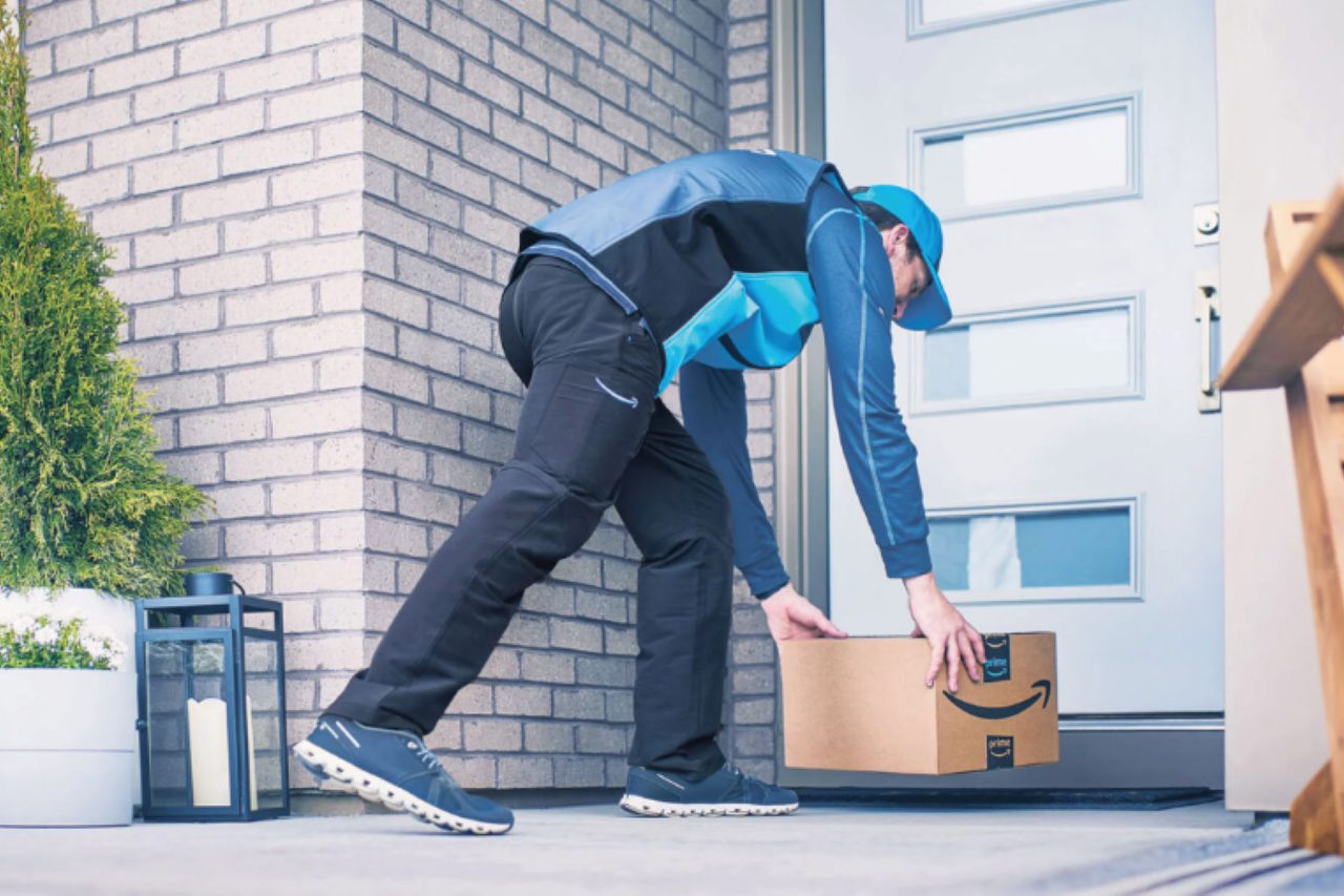 Vendre sur Amazon Livreur déposant un colis Amazon devant la porte